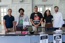 students standing with signage at a desk