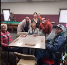 youth and senior adults pose seated at table