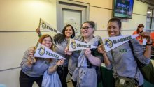 staff posed with njcu banners