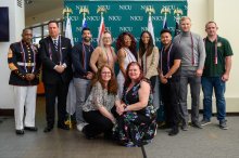 group of people pose with and without military uniforms